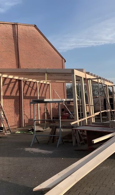 Holzrahmenkonstruktion im Aufbau an Backsteingebäude